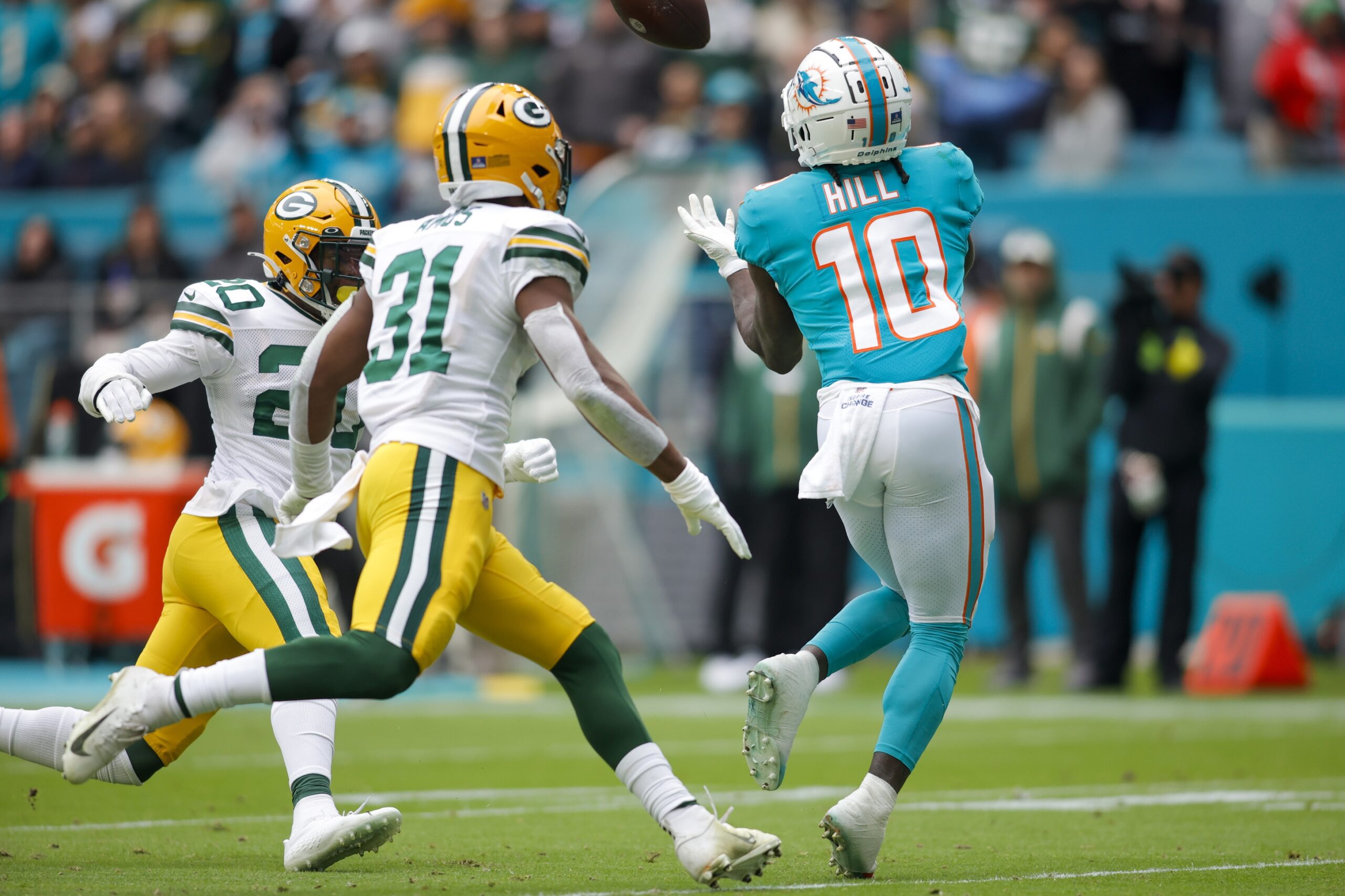 Dec 25, 2022; Miami Gardens, Florida, USA; Miami Dolphins wide receiver Tyreek Hill (10) catches the football ahead of Green Bay Packers safety Rudy Ford (20) and safety Adrian Amos (31) during the second quarter at Hard Rock Stadium. Mandatory Credit: Sam Navarro-USA TODAY Sports