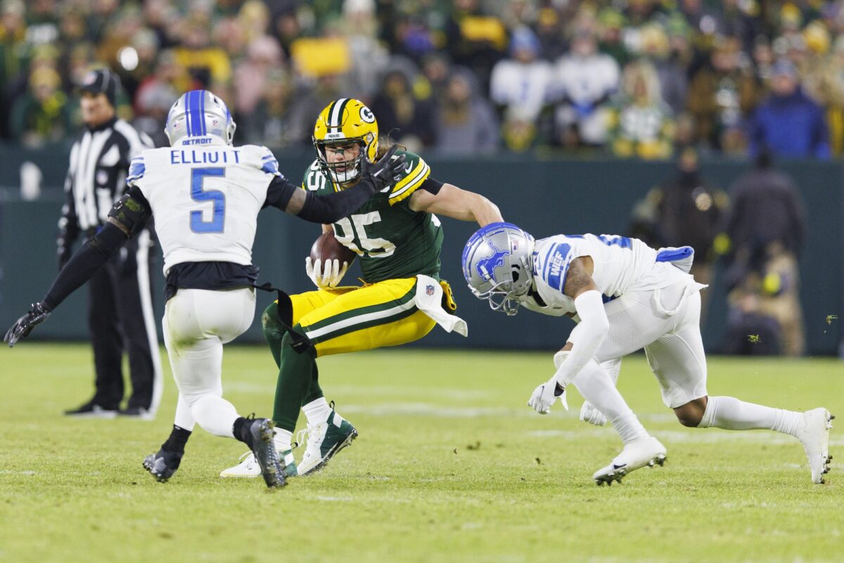 Jan 8, 2023; Green Bay, Wisconsin, USA; Green Bay Packers tight end Robert Tonyan (85) rushes with the football after catching a pass as Detroit Lions safety DeShon Elliott (5) and cornerback Mike Hughes (23) defend during the second quarter at Lambeau Field. Mandatory Credit: Jeff Hanisch-USA TODAY Sports