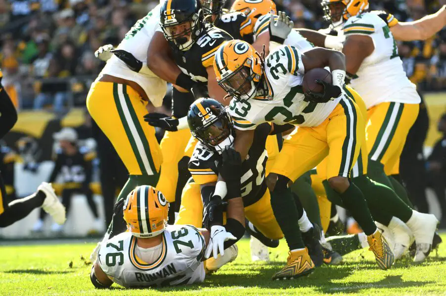 Nov 12, 2023; Pittsburgh, Pennsylvania, USA; Green Bay Packers running back Aaron Jones (33) is slowed by Pittsburgh Steelers linebacker Elandon Roberts (50) during the first quarter at Acrisure Stadium. Mandatory Credit: Philip G. Pavely-USA TODAY Sports