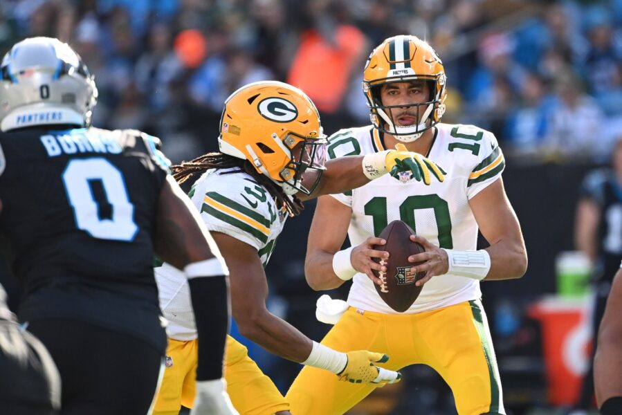 Dec 24, 2023; Charlotte, North Carolina, USA; Green Bay Packers quarterback Jordan Love (10) looks to pass as running back Aaron Jones (33) fakes receiving the ball and Carolina Panthers linebacker Brian Burns (0) defends in the second quarter at Bank of America Stadium. Mandatory Credit: Bob Donnan-USA TODAY Sports