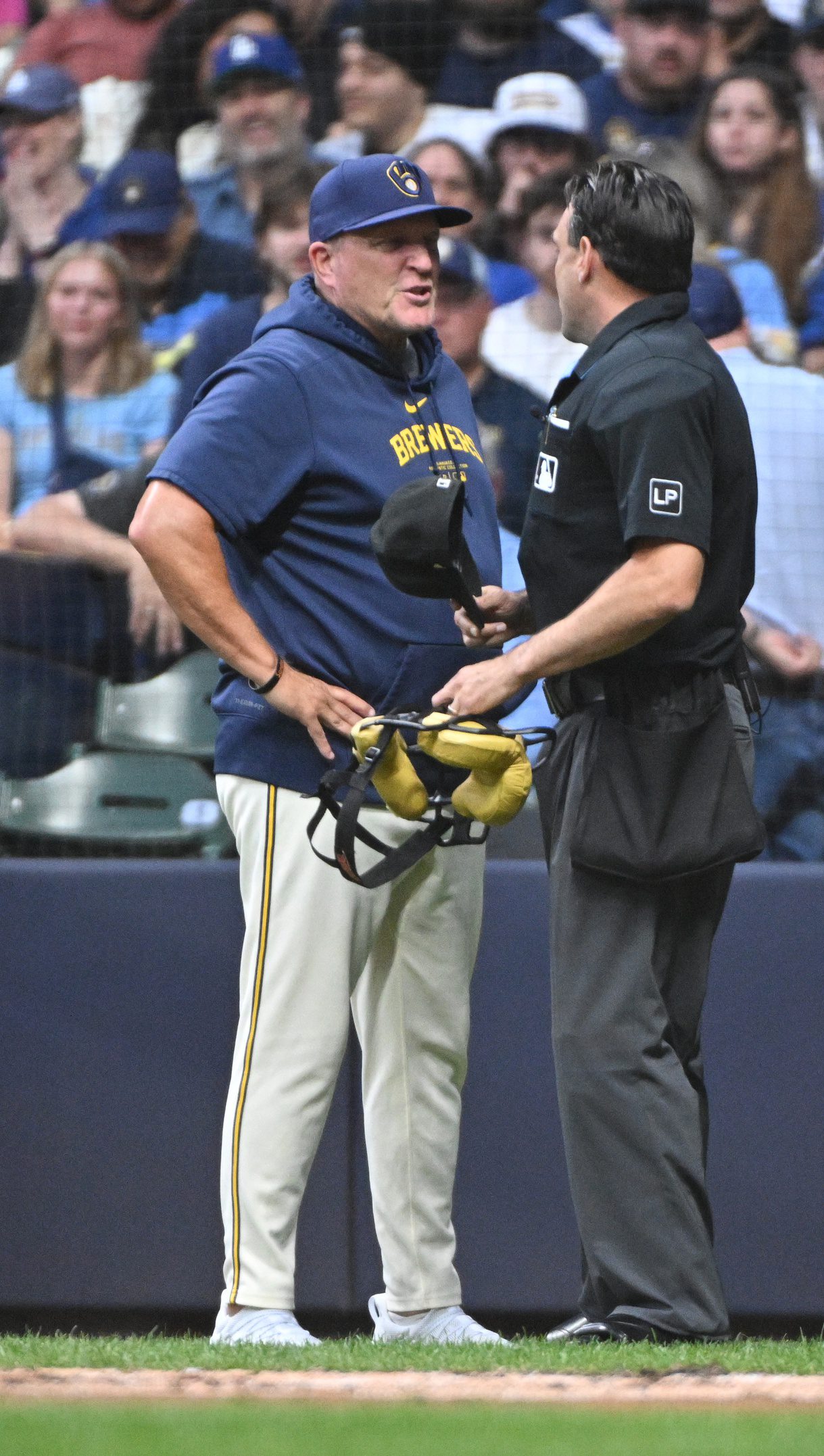 Aug 14, 2024; Milwaukee, Wisconsin, USA; Milwaukee Brewers manager Pat Murphy (21) talks with umpire Alex Tosi (66) during the second inning at American Family Field. Mandatory Credit: Michael McLoone-USA TODAY Sports