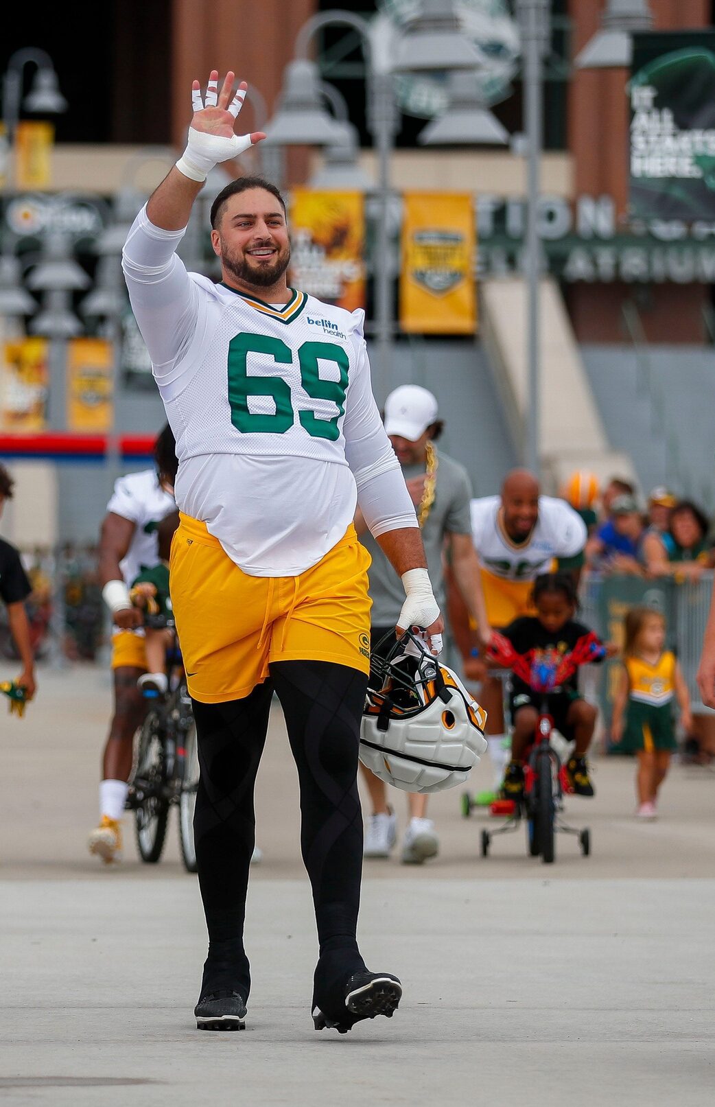 Green Bay Packers offensive tackle David Bakhtiari (69) waves to fans as he walks from Lambeau Field to practice during the first day of practice at training camp at Ray Nitschke Field on Wednesday, July 26, 2023, in Green Bay, Wis.