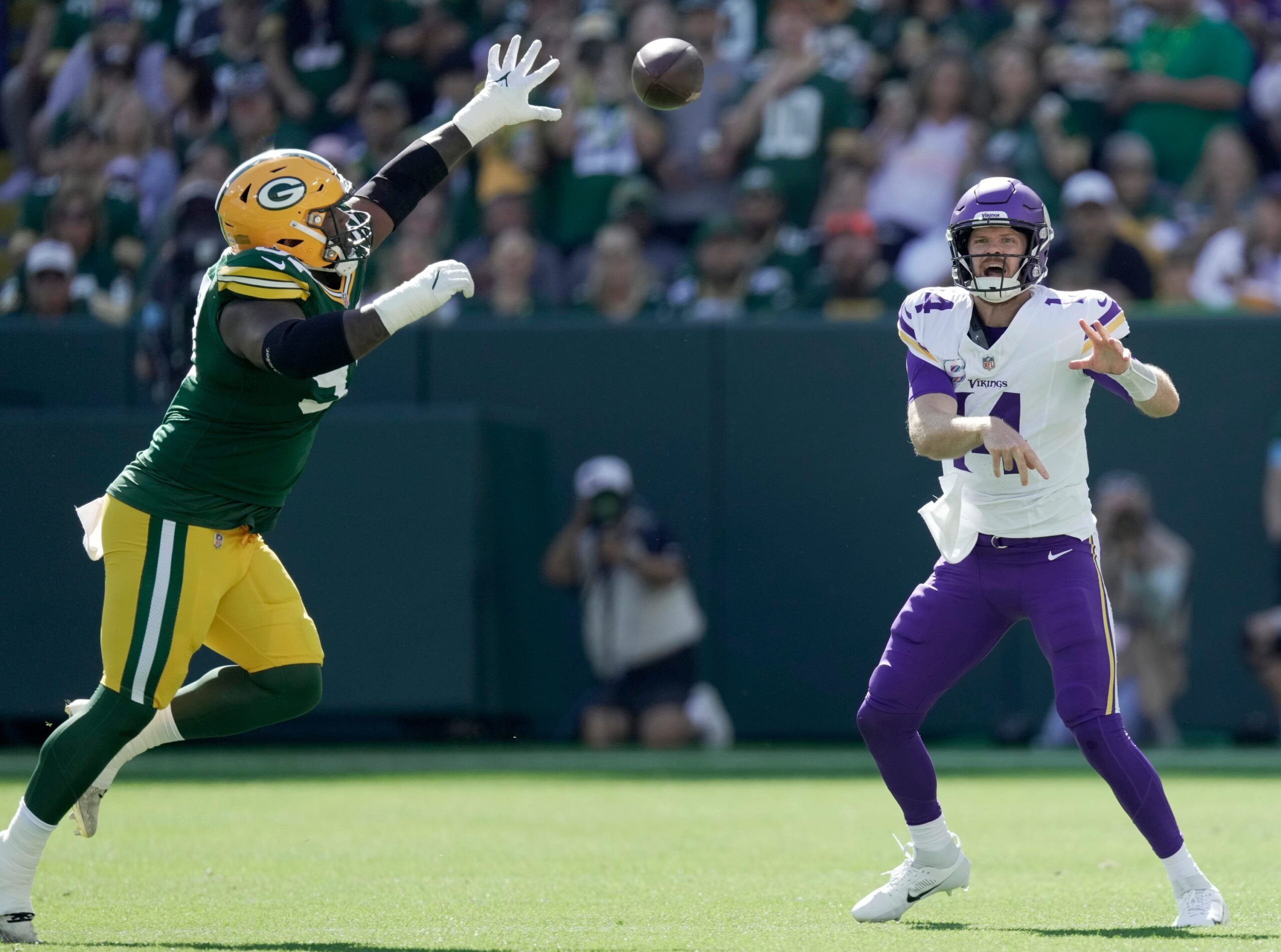 Minnesota Vikings quarterback Sam Darnold (14) is presses by Green Bay Packers defensive tackle Kenny Clark (97) during the first quarter of their game Sunday, September 29, 2024 at Lambeau Field in Green Bay, Wisconsin.