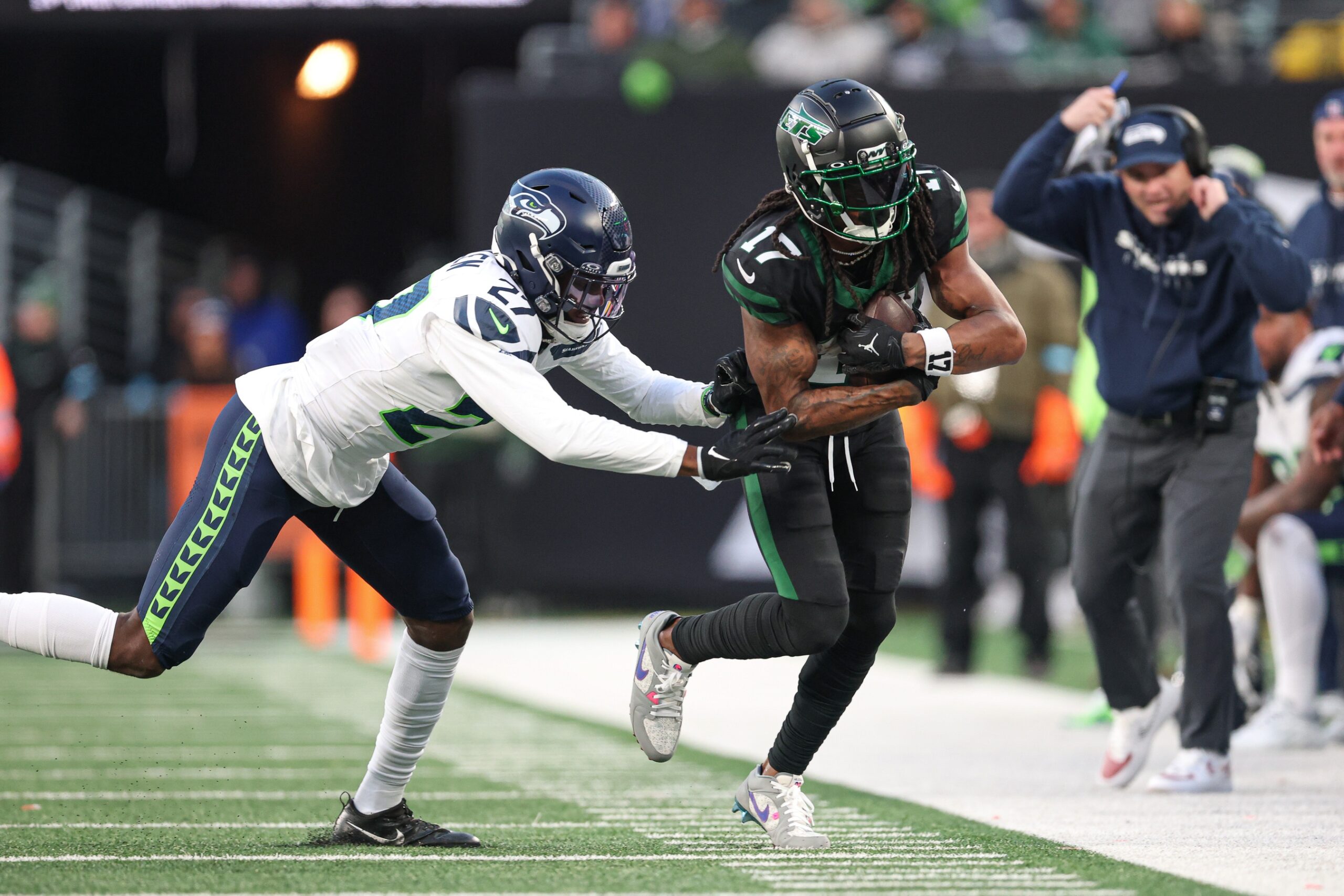 Dec 1, 2024; East Rutherford, New Jersey, USA; New York Jets wide receiver Davante Adams (17) is tackled by Seattle Seahawks cornerback Riq Woolen (27) during the second half at MetLife Stadium. Mandatory Credit: Vincent Carchietta-Imagn Images Packers