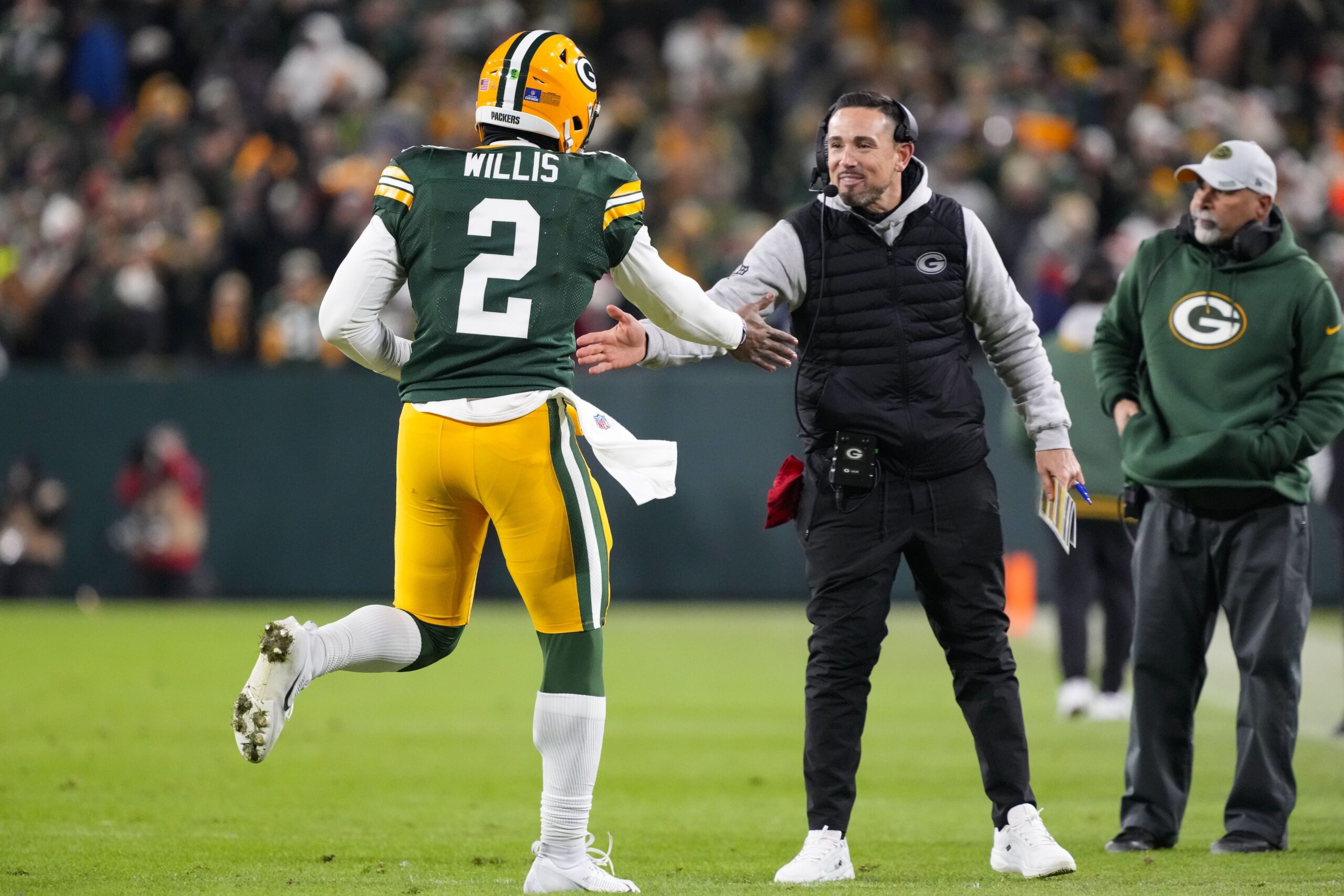 Dec 23, 2024; Green Bay, Wisconsin, USA;  Green Bay Packers head coach Matt LaFleur greets quarterback Malik Willis (2) following a touchdown during the fourth quarter against the New Orleans Saints at Lambeau Field. Mandatory Credit: Jeff Hanisch-Imagn Images