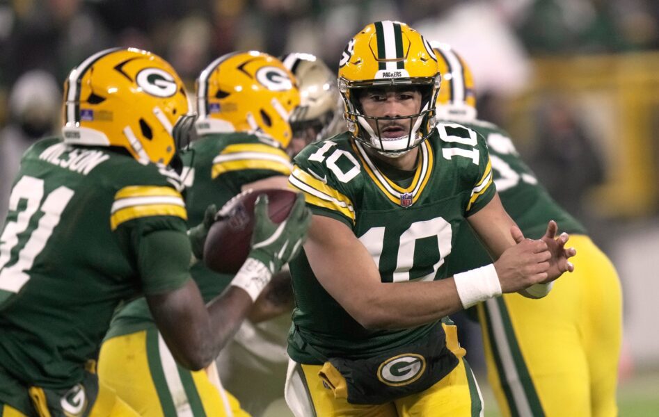 Green Bay Packers quarterback Jordan Love (10) pitches the ball to running back Emanuel Wilson (31)