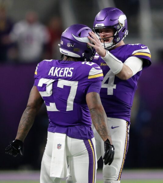 Minnesota Vikings quarterback Sam Darnold (14) celebrating with running back Cam Akers (27)