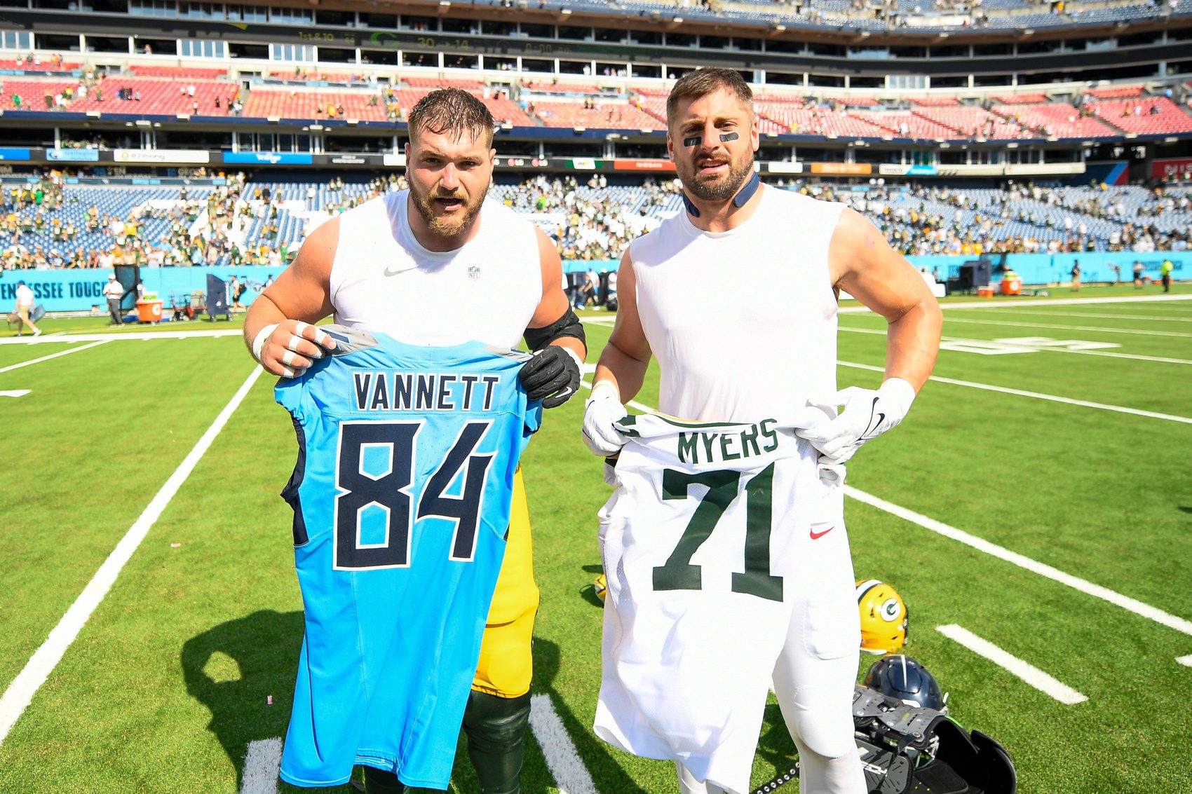 Sep 22, 2024; Nashville, Tennessee, USA; Green Bay Packers center Josh Myers (71) and Tennessee Titans tight end Nick Vannett (84) swap jersey during the second half at Nissan Stadium. Mandatory Credit: Steve Roberts-Imagn Images