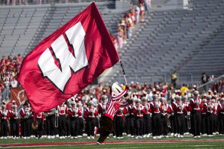 Bucky Badger carries a Wisconsin flag prior to the game at Camp Randall Stadium.