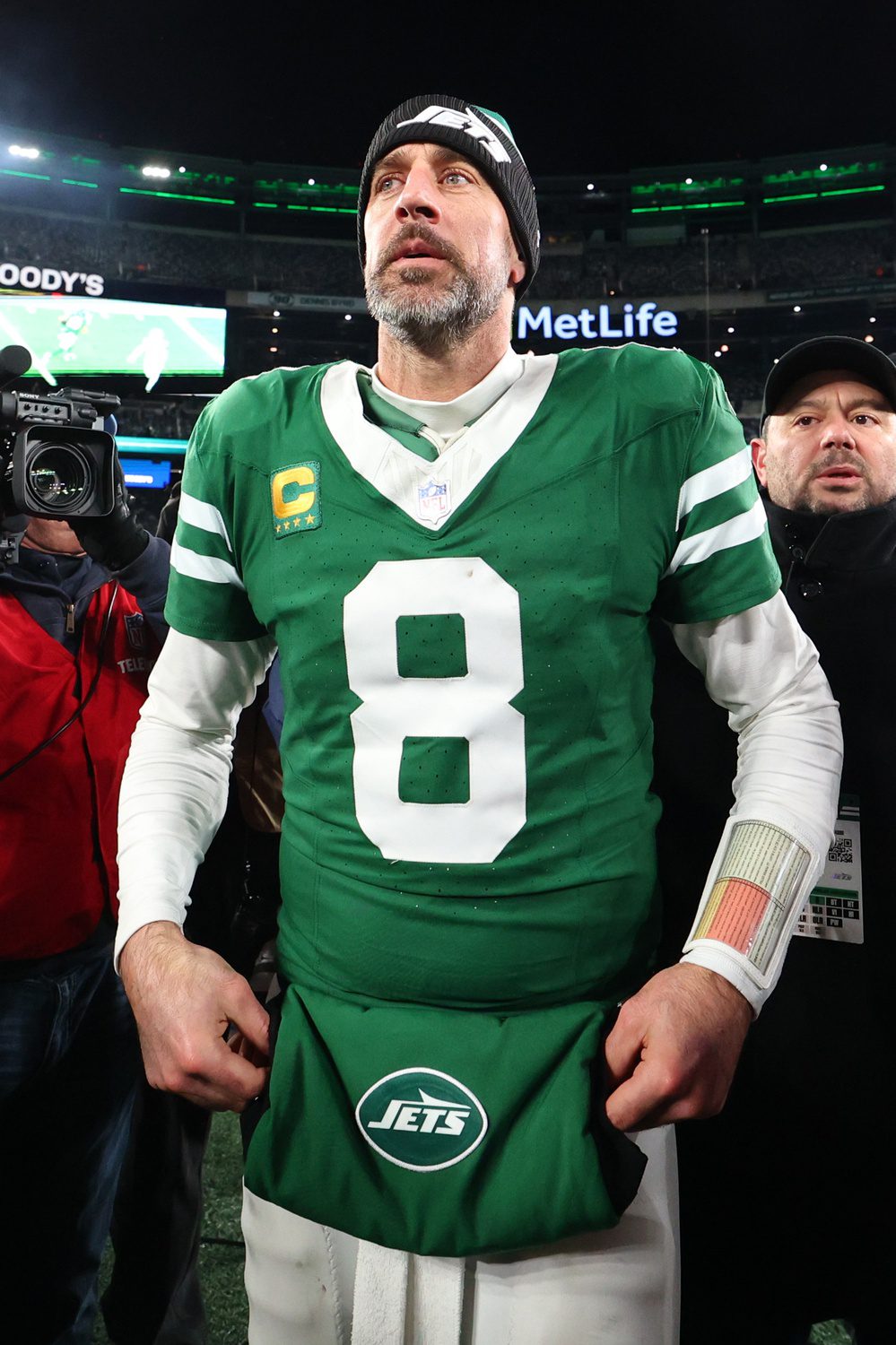 Jan 5, 2025; East Rutherford, New Jersey, USA; New York Jets quarterback Aaron Rodgers (8) walks on the field after the Jets win over the Miami Dolphins at MetLife Stadium. Mandatory Credit: Ed Mulholland-Imagn Images