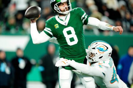 New York Jets quarterback Aaron Rodgers (8) throws a pass before Miami Dolphins linebacker Chop Robinson (44) could take him down, Sunday January 5, 2025, in East Rutherford.