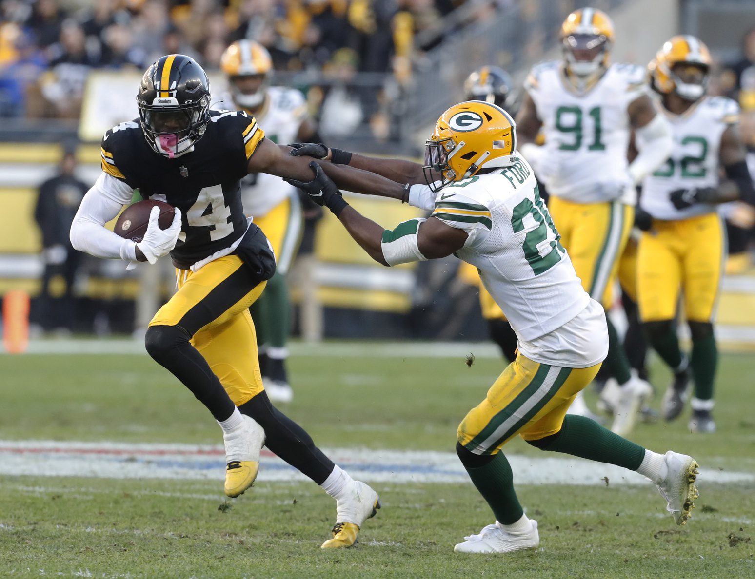 Nov 12, 2023; Pittsburgh, Pennsylvania, USA; Pittsburgh Steelers wide receiver George Pickens (14) runs after a catch against Green Bay Packers safety Rudy Ford (20) during the fourth quarter at Acrisure Stadium. Pittsburgh won 23-19. Mandatory Credit: Charles LeClaire-Imagn Images