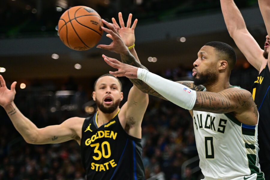 Feb 10, 2025; Milwaukee, Wisconsin, USA; Milwaukee Bucks guard Damian Lillard (0) passes the ball away from Golden State Warriors guard Stephen Curry (30) in the fourth quarter at Fiserv Forum. Mandatory Credit: Benny Sieu-Imagn Images