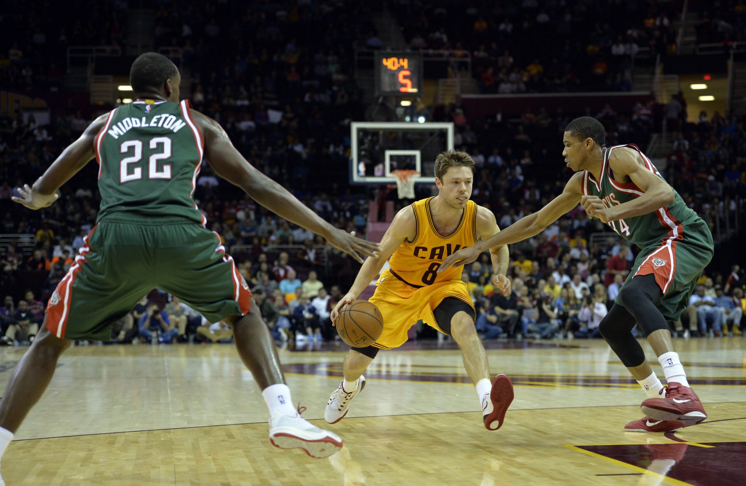 Oct 14, 2014; Cleveland, OH, USA; Cleveland Cavaliers guard Matthew Dellavedova (8) drives between Milwaukee Bucks forward Khris Middleton (22) and guard Giannis Antetokounmpo (34) in the second quarter at Quicken Loans Arena. Mandatory Credit: David Richard-USA TODAY Sports