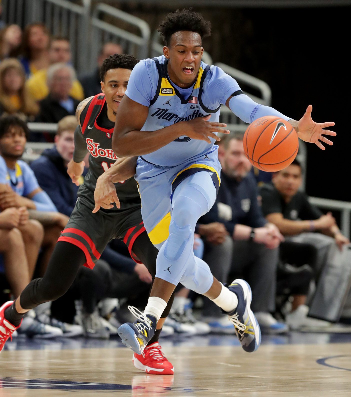 Marquette forward Olivier-Maxence Prosper (12) snares a loose ball from St. John's guard Tareq Coburn (10) during the first half of their game Saturday, March 5, 2022, at Fiserv Forum in Milwaukee. © Mark Hoffman / Milwaukee Journal Sentinel / USA TODAY NETWORK