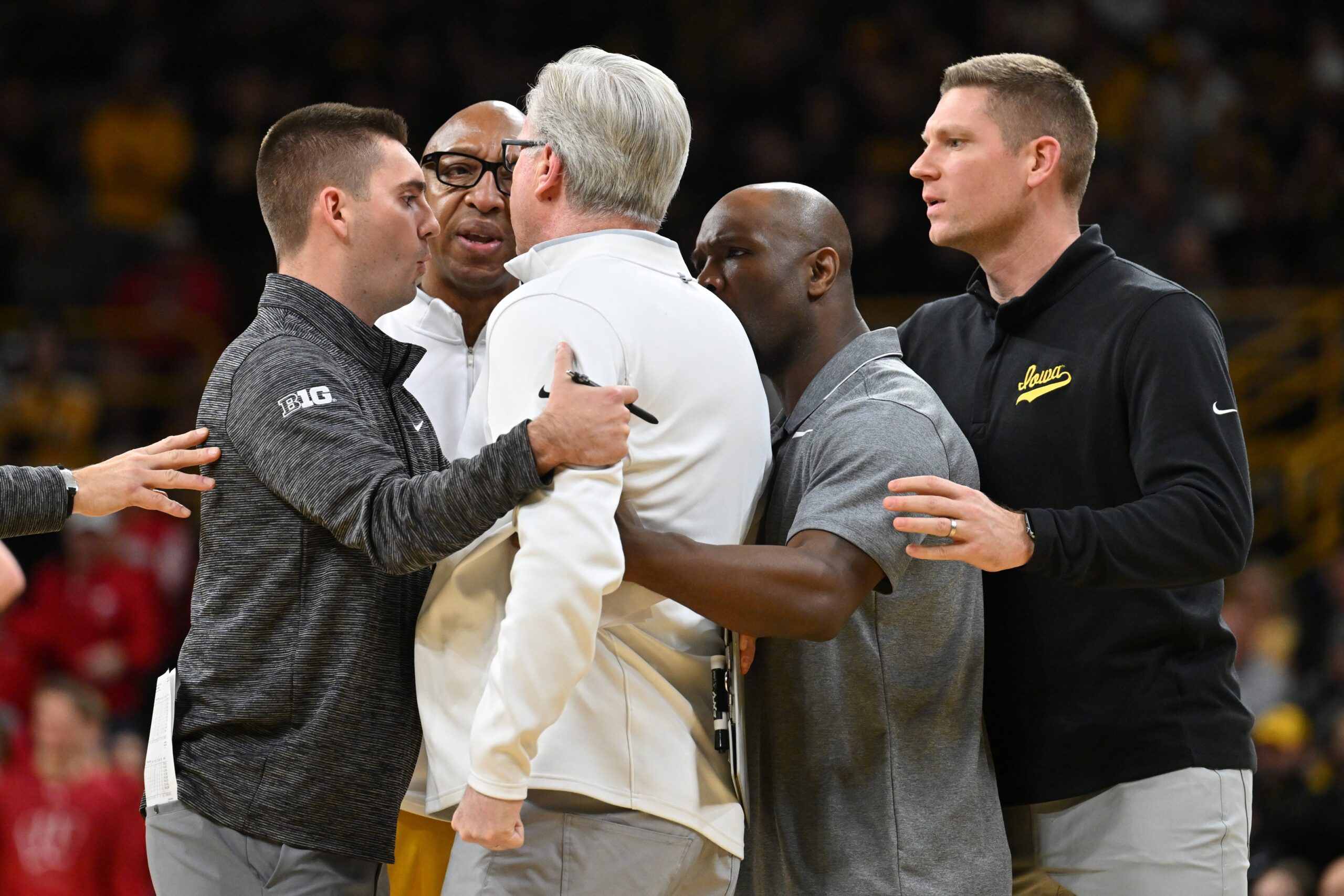 Dec 11, 2022; Iowa City, Iowa, USA; Iowa Hawkeyes head coach Fran McCaffery is held back by assistant coaches during the second half against the Wisconsin Badgers at Carver-Hawkeye Arena. Mandatory Credit: Jeffrey Becker-Imagn Images