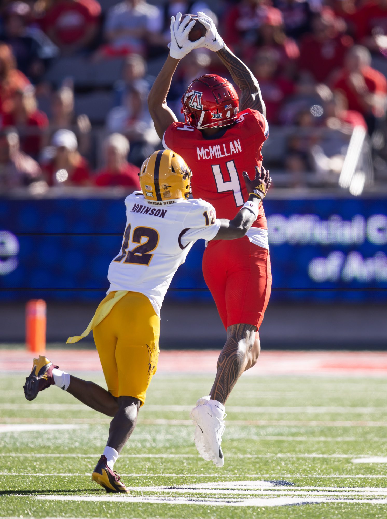 Nov 30, 2024; Tucson, Arizona, USA; Arizona Wildcats wide receiver Tetairoa McMillan (4) catches a pass against Arizona State Sun Devils defensive back Javan Robinson (12) during the Territorial Cup at Arizona Stadium. Mandatory Credit: Mark J. Rebilas-Imagn ImagesPackers
