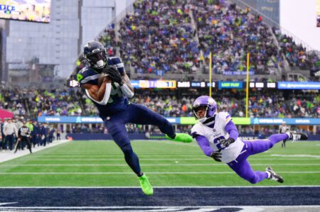 Dec 22, 2024; Seattle, Washington, USA; Seattle Seahawks wide receiver DK Metcalf (14) catches a pass for a touchdown while defended by Minnesota Vikings cornerback Stephon Gilmore (2) during the first half at Lumen Field. Mandatory Credit: Steven Bisig-Imagn Images