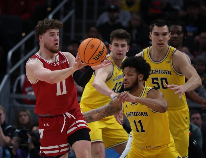 Mar 16, 2025; Indianapolis, IN, USA; Wisconsin Badgers guard Max Klesmit (11) passes the ball to a teammate past the hands of Michigan Wolverines guard Roddy Gayle Jr. (11) during the first half during the 2025 Big Ten Championship Game at Gainbridge Fieldhouse. Mandatory Credit: Trevor Ruszkowski-Imagn Images