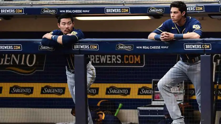 Brewers' outfielder Christian Yelich and second baseman Keston Hiura look on from the dugout during a 2020 regular season game.