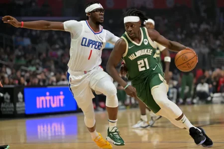 Jrue Holiday of the Milwaukee Bucks drives past Reggie Jackson of the Los Angeles Clippers