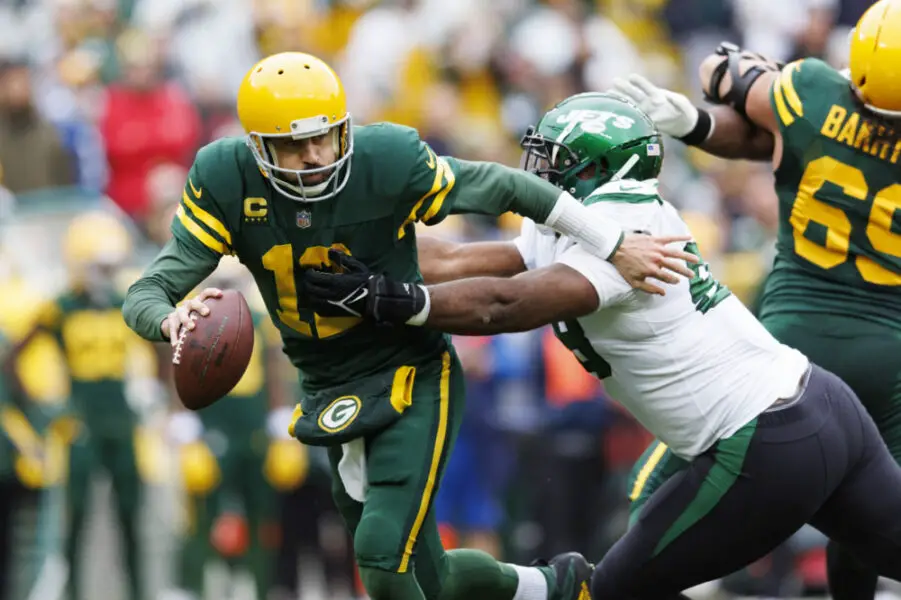 Oct 16, 2022; Green Bay, Wisconsin, USA; Green Bay Packers quarterback Aaron Rodgers (12) avoids pressure from New York Jets nose tackle Quinnen Williams (95) during the second quarter at Lambeau Field. Mandatory Credit: Jeff Hanisch-USA TODAY Sports