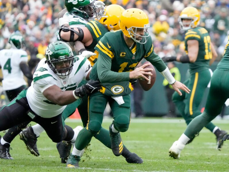 Green Bay Packers quarterback Aaron Rodgers tries to escape Jets defensive tackle Sheldon Rankins during the first half of their game at Lambeau Field in Green Bay on Oct. 16, 2022. Syndication Journal Sentinel