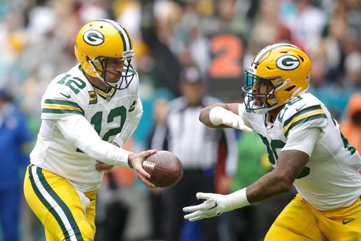 Dec 25, 2022; Miami Gardens, Florida, USA; Green Bay Packers quarterback Aaron Rodgers (12) hands-out the football to running back AJ Dillon (28) during the second quarter at Hard Rock Stadium. Mandatory Credit: Sam Navarro-USA TODAY Sports