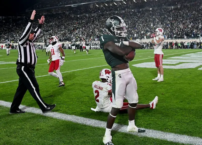 Oct 15, 2022; East Lansing, Michigan, USA; Michigan State Spartans wide receiver Jayden Reed (1) catches a touchdown pass in spite of Wisconsin Badgers cornerback Ricardo Hallman (2) in a second overtime period to win the game, 34-28, at Spartan Stadium. Mandatory Credit: Dale Young-USA TODAY Sports (NFL - Green Bay Packers)