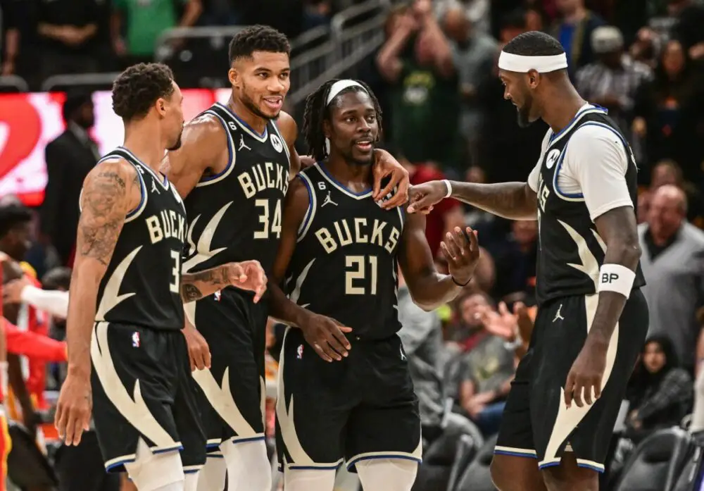 Oct 29, 2022; Milwaukee, Wisconsin, USA; Milwaukee Bucks guard George Hill (3) and forward Giannis Antetokounmpo (34) and guard Jrue Holiday (21) and forward Bobby Portis (9) celebrate after a score late in the fourth quarter during game against the Atlanta Hawks at Fiserv Forum. Mandatory Credit: Benny Sieu-USA TODAY Sports (NBA News)