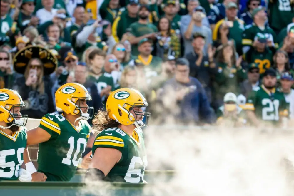 Offensive tackle David Bakhtiari, right, and Jordan Love, center, lead the Packers onto the field for a 2022 game against the Patriots. Syndication Packersnews. © Samantha Madar / USA TODAY NETWORK