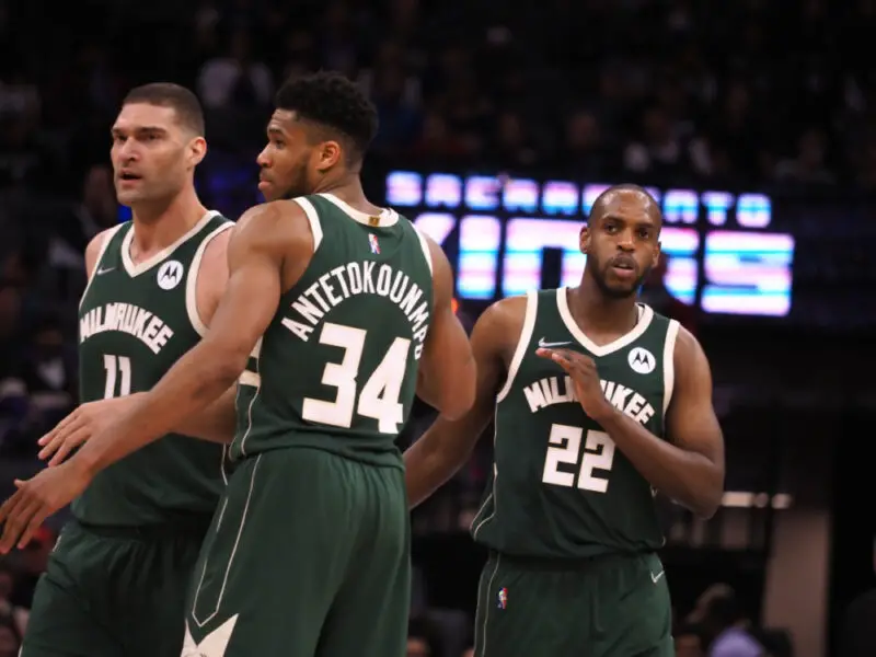 Mar 16, 2022; Sacramento, California, USA; Milwaukee Bucks forward Khris Middleton (22) celebrates with center Brook Lopez (11) and forward Giannis Antetokounmpo (34) after a play against the Sacramento Kings during the fourth quarter at Golden 1 Center. Mandatory Credit: Kelley L Cox-USA TODAY Sports (NBA News)