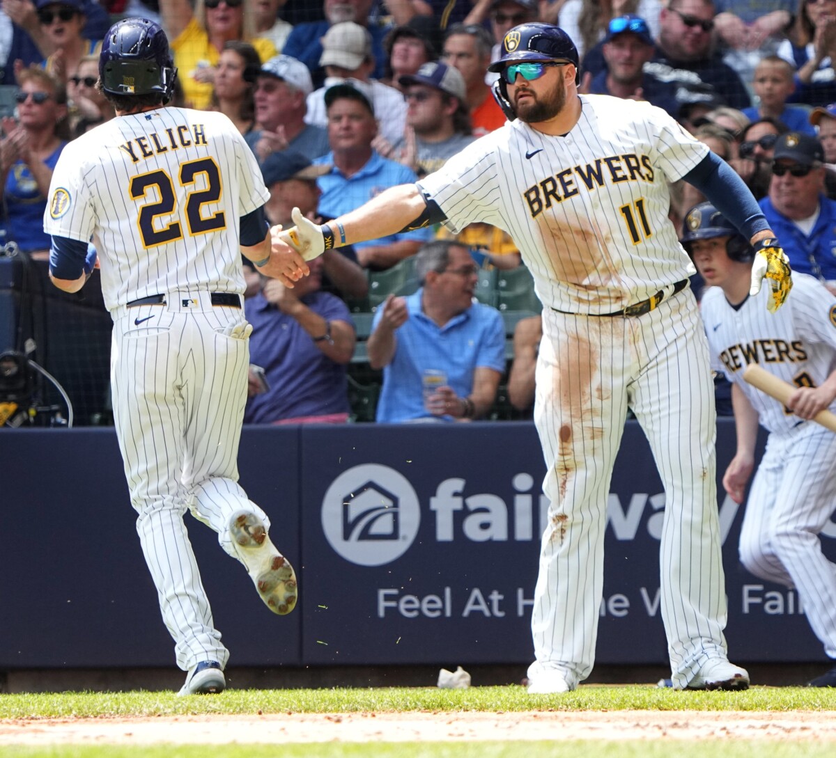 Milwaukee Brewers left fielder Christian Yelich (22) is congratulated by first baseman Rowdy Tellez (11) after coring on a single by catcher William Contreras during the first inning of their game against the San Francisco Giants Sunday, May 28, 2023 at American Family Field in Milwaukee, Wis. (MLB News)