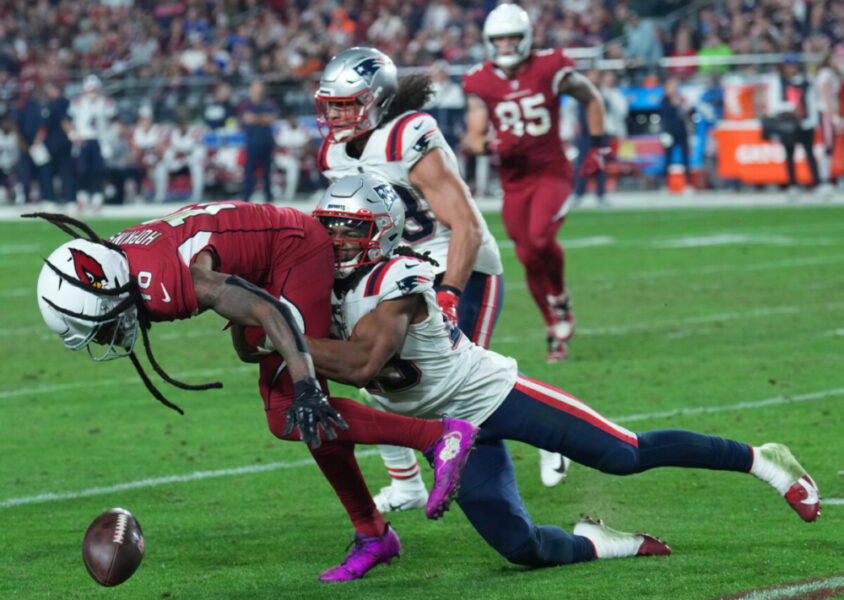 Dec 12, 2022; Glendale, Arizona, USA; New England Patriots safety Kyle Dugger (23) strips the ball away from Arizona Cardinals wide receiver DeAndre Hopkins (10) during the second half at State Farm Stadium. Mandatory Credit: Joe Camporeale-USA TODAY Sports (NFL News)