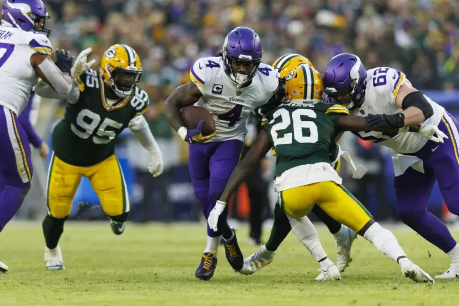 Jan 1, 2023; Green Bay, Wisconsin, USA; Minnesota Vikings running back Dalvin Cook (4) rushes with the football as Green Bay Packers safety Darnell Savage (26) defends during the first quarter at Lambeau Field. Mandatory Credit: Jeff Hanisch-USA TODAY Sports - NFL News