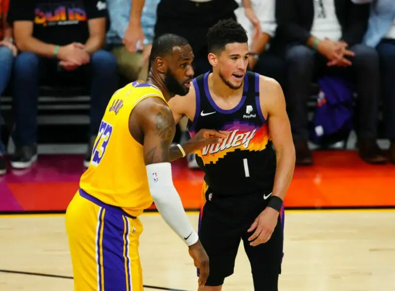 May 25, 2021; Phoenix, Arizona, USA; Los Angeles Lakers forward LeBron James (23) against Phoenix Suns guard Devin Booker (1) during the second half in game two of the first round of the 2021 NBA Playoffs at Phoenix Suns Arena. Mandatory Credit: Mark J. Rebilas-USA TODAY Sports (NBA News)