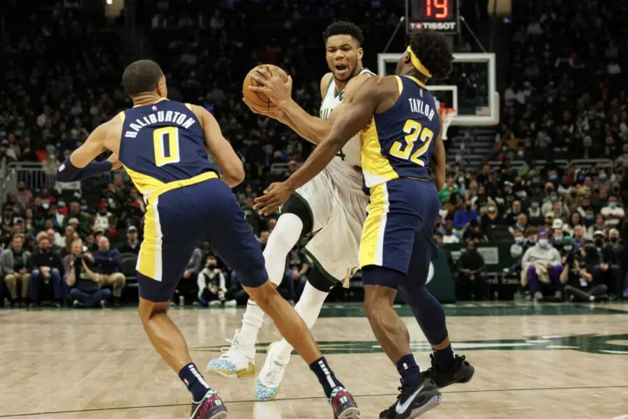 Feb 15, 2022; Milwaukee, Wisconsin, USA; Milwaukee Bucks forward Giannis Antetokounmpo (34) drives for the basket between Indiana Pacers guard Tyrese Haliburton (0) and forward Terry Taylor (32) during the second quarter at Fiserv Forum. Mandatory Credit: Jeff Hanisch-USA TODAY Sports (NBA News)