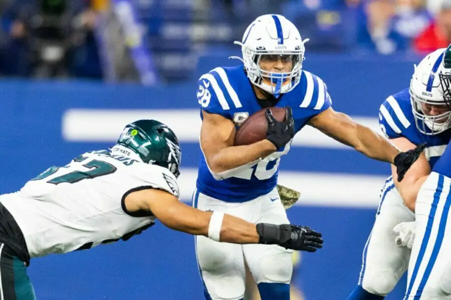 Nov 20, 2022; Indianapolis, Indiana, USA; Indianapolis Colts running back Jonathan Taylor (28) runs the ball while Philadelphia Eagles linebacker T.J. Edwards (57) defends in the second half at Lucas Oil Stadium. Mandatory Credit: Trevor Ruszkowski-USA TODAY Sports (NFL News)