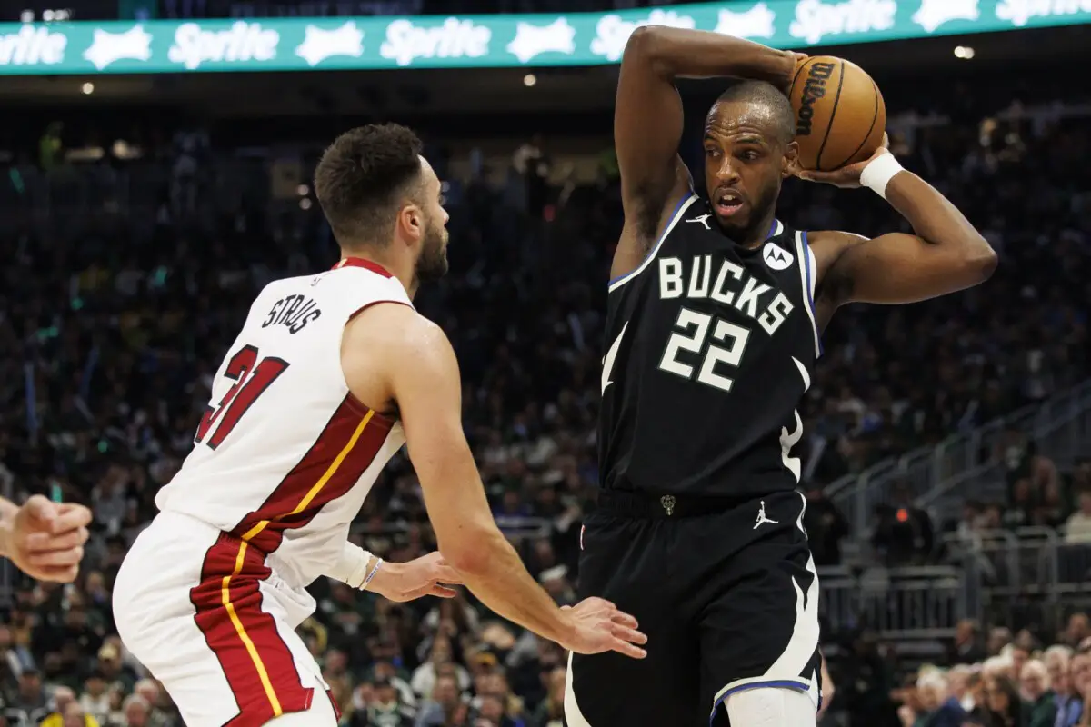 Apr 19, 2023; Milwaukee, Wisconsin, USA; Milwaukee Bucks forward Khris Middleton (22) holds the ball away from Miami Heat guard Max Strus (31) during the third quarter during game two of the 2023 NBA Playoffs at Fiserv Forum. Mandatory Credit: Jeff Hanisch-USA TODAY Sports (NBA News)