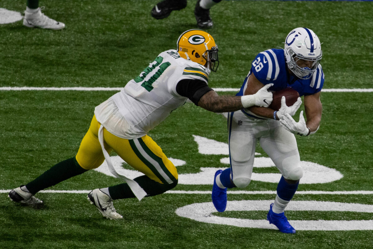 Nov 22, 2020; Indianapolis, Indiana, USA; Indianapolis Colts running back Jonathan Taylor (28) runs the ball while Green Bay Packers outside linebacker Preston Smith (91) defends in the first half at Lucas Oil Stadium. Mandatory Credit: Trevor Ruszkowski-USA TODAY Sports