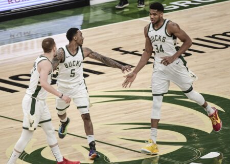 May 5, 2021; Milwaukee, Wisconsin, USA; Milwaukee Bucks guard Jeff Teague (5) reacts after scoring a three-point basket with an assist from forward Giannis Antetokounmpo (34) in the second quarter against the Washington Wizards at Fiserv Forum. Mandatory Credit: Benny Sieu-USA TODAY Sports (NBA News)