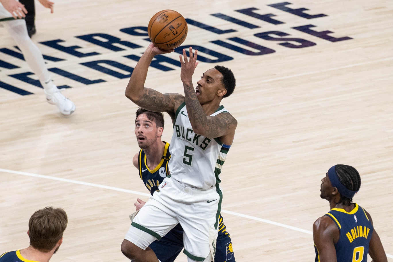 May 13, 2021; Indianapolis, Indiana, USA; Milwaukee Bucks guard Jeff Teague (5) shoots the ball while Indiana Pacers guard T.J. McConnell (9) defends in the first quarter at Bankers Life Fieldhouse. Mandatory Credit: Trevor Ruszkowski-USA TODAY Sports NBA News