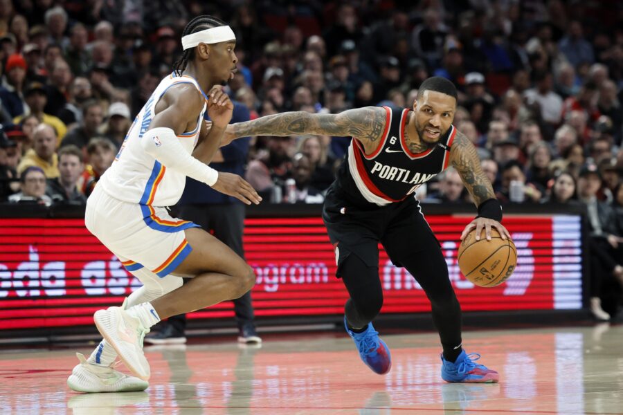 Feb 10, 2023; Portland, Oregon, USA; Portland Trail Blazers point guard Damian Lillard (0) dribbles the ball while defended by Oklahoma City Thunder point guard Shai Gilgeous-Alexander (2, left) during the first half at Moda Center. Mandatory Credit: Soobum Im-USA TODAY Sports