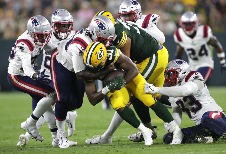Aug 19, 2023; Green Bay, WI, USA; Green Bay Packers running back Emanuel Wilson (31) is brought down by the New England Patriots defense during their preseason football game at Lambeau Field. The game was suspended in the fourth quarter following an injury to New England Patriots cornerback Isaiah Bolden (7). Mandatory Credit: Dan Powers-USA TODAY Sports