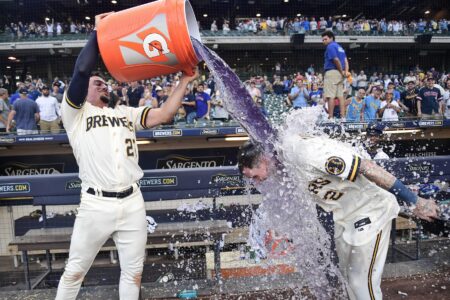 Aug 23, 2023; Milwaukee, Wisconsin, USA; Milwaukee Brewers second baseman Brice Turang (2) is dunked by shortstop Willy Adames (27) after driving in the winning run in the tenth inning against the Minnesota Twins at American Family Field. Mandatory Credit: Benny Sieu-USA TODAY Sports