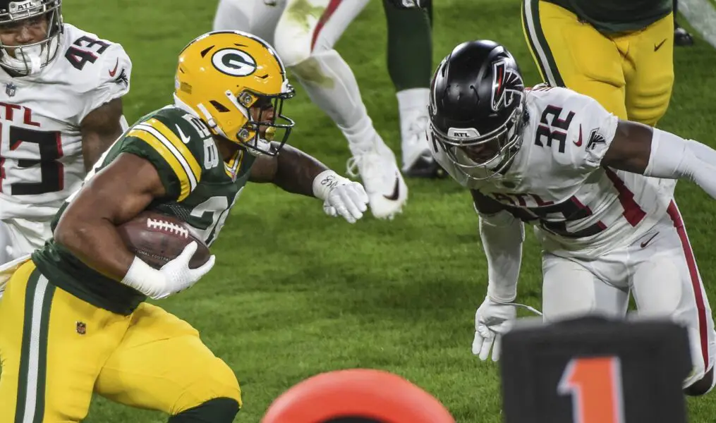 Oct 5, 2020; Green Bay, Wisconsin, USA; Green Bay Packers running back AJ Dillon (28) tries to evade a tackle by Atlanta Falcons safety Jaylinn Hawkins (32) in the second quarter at Lambeau Field. Mandatory Credit: Benny Sieu-USA TODAY Sports