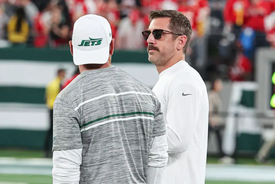 Oct 1, 2023; East Rutherford, New Jersey, USA; New York Jets quarterback Aaron Rodgers (8) talks with a member of the Jets staff before the game against the Kansas City Chiefs at MetLife Stadium. Mandatory Credit: Vincent Carchietta-USA TODAY Sports (Green Bay Packers)
