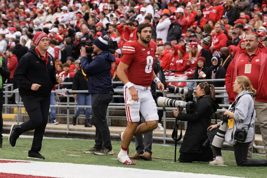 Wisconsin Badgers quarterback Tanner Mordecai walks off the field with a hand injury.