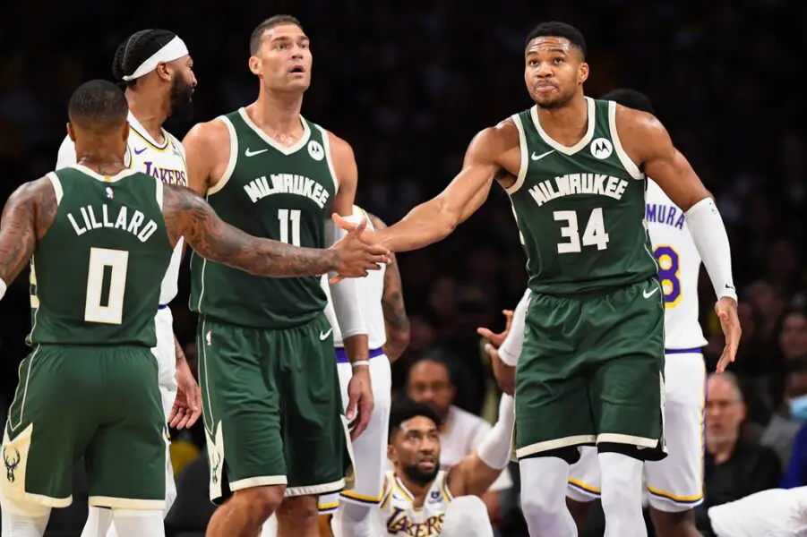 Oct 15, 2023; Los Angeles, California, USA; Milwaukee Bucks forward Giannis Antetokounmpo (34) celebrates with guard Damian Lillard (0) and center Brook Lopez (11) against the Los Angeles Lakers during the first quarter at Crypto.com Arena. Mandatory Credit: Jonathan Hui-USA TODAY Sports
