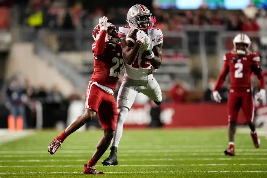 Oct 28, 2023; Madison, Wisconsin, USA; Ohio State Buckeyes wide receiver Marvin Harrison Jr. (18) catches a pass while defended by Wisconsin Badgers cornerback Jason Maitre (23) during the first half of the NCAA football game at Camp Randall Stadium. (Green Bay Packers)